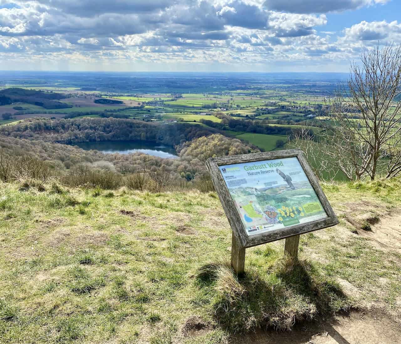 Amazing views of Gormire Lake and the sprawling flatland of the Vale of Mowbray, as seen from the Cleveland Way above Whitestone Cliff on the Gormire Lake walk.