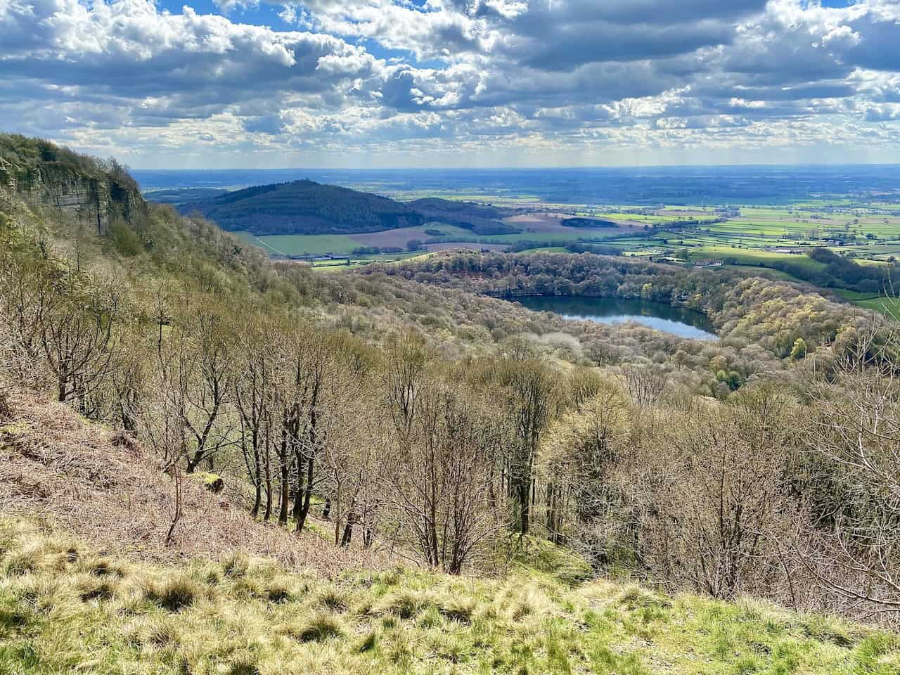 Amazing views of Gormire Lake and the sprawling flatland of the Vale of Mowbray, as seen from the Cleveland Way above Whitestone Cliff on the Gormire Lake walk.