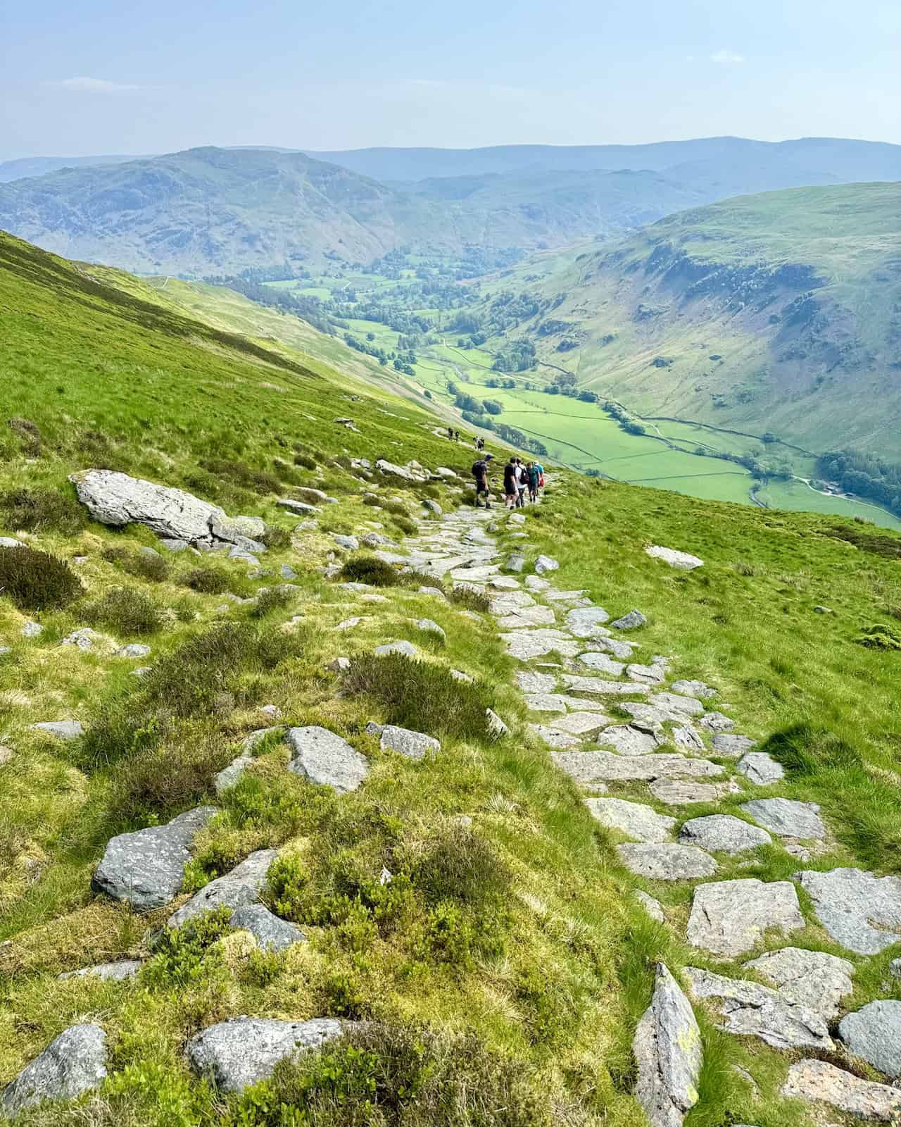 Looking back down into the Grisedale valley, we notice Birks on the right and Place Fell beyond Patterdale. The well-maintained path makes the ascent more manageable.