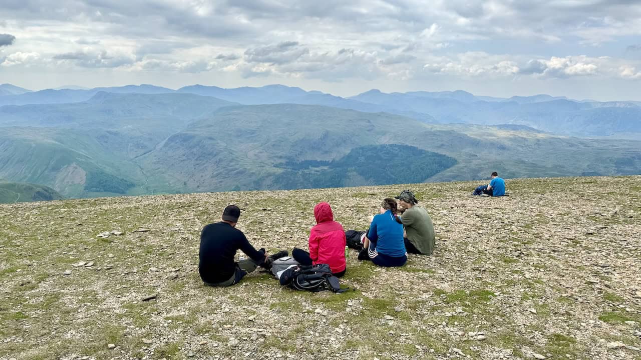 Hikers relax and relish the expansive views from Helvellyn’s peak.