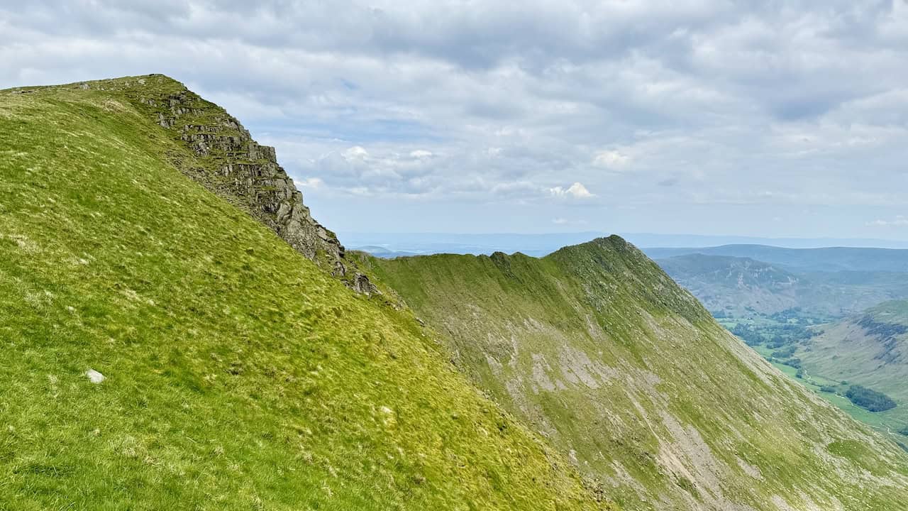 On the route between Helvellyn and Nethermost Pike, we look back at Striding Edge, which we crossed earlier on our Helvellyn via Striding Edge walk. Lad Crag appears on the left, adding to the rugged beauty.