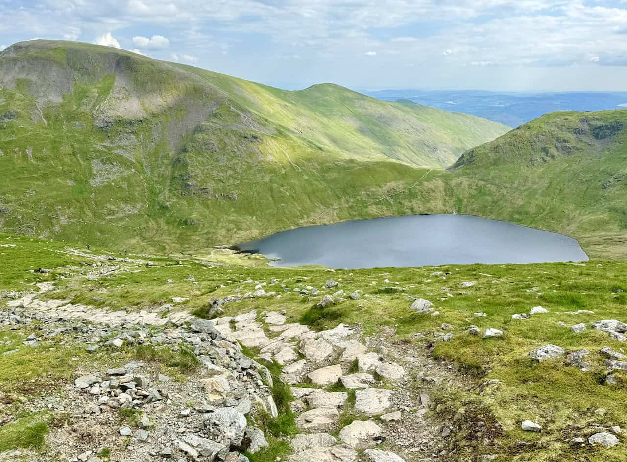 The stepped path down from Dollywaggon Pike to Grisedale Tarn reveals Fairfield to the left and Seat Sandal to the right, with Grisedale Hause between them. The ridge from Fairfield forms part of the popular Fairfield Horseshoe, including Great Rigg and Heron Pike.