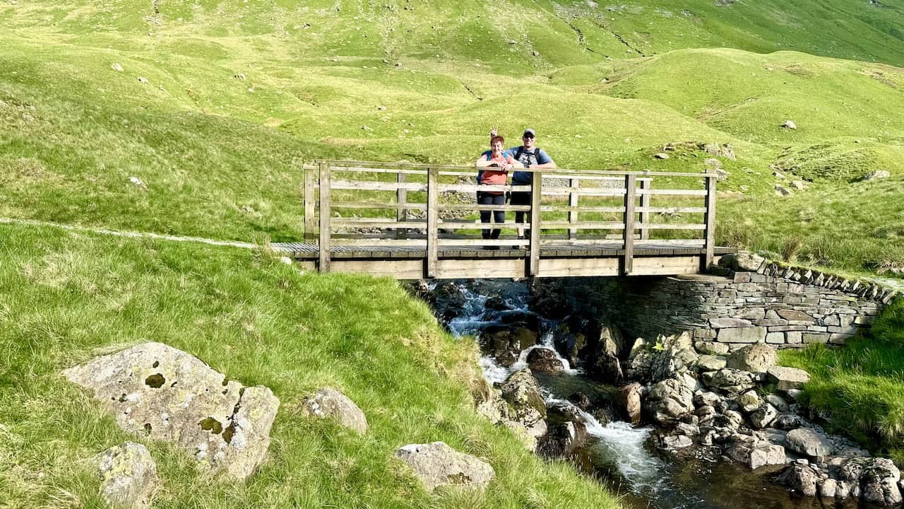 Jeff and Sandra cross the footbridge over Grisedale Beck, enjoying the picturesque scenery.