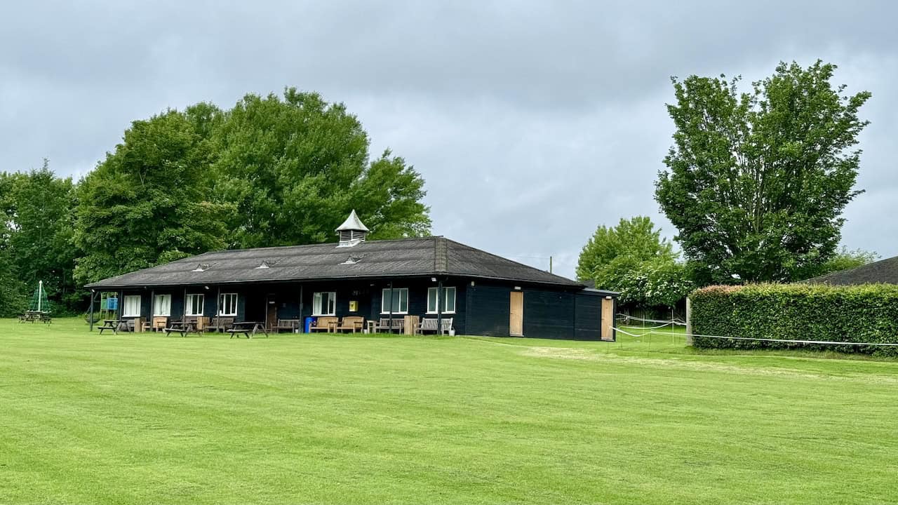 The view across the cricket field towards the pavilion of Helmsley Sports Club showcases a vibrant community hub.