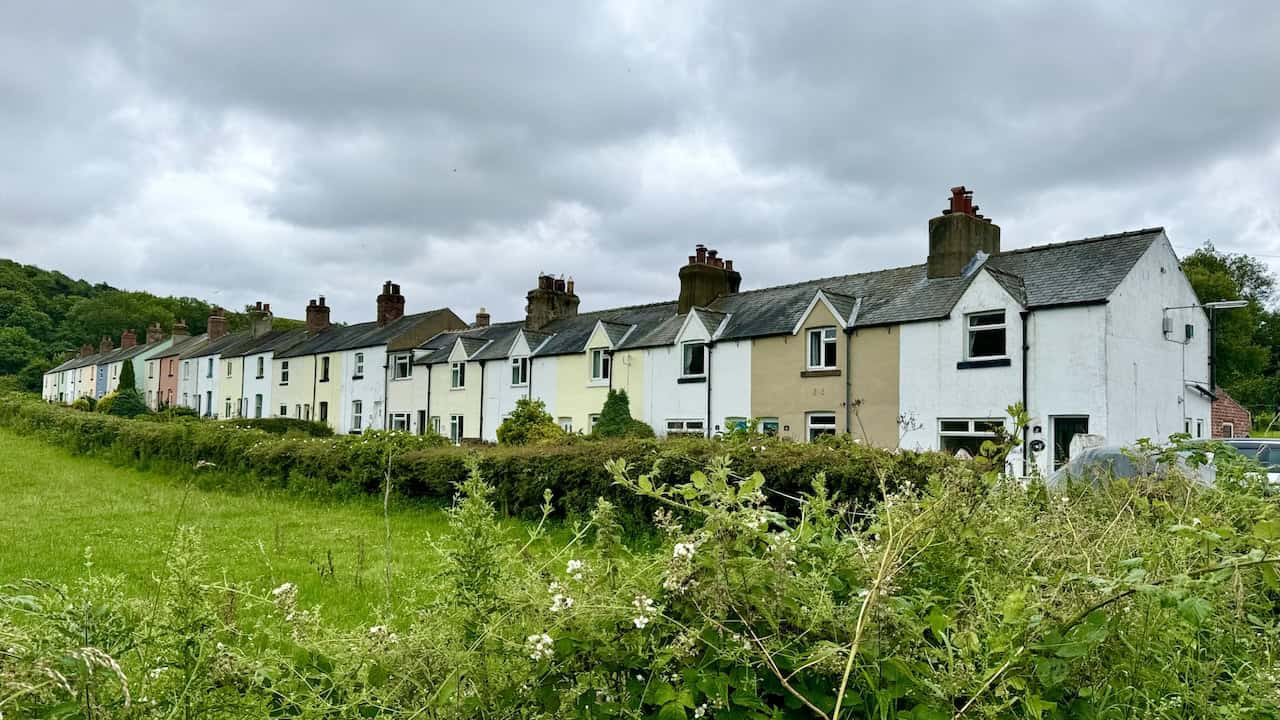 Row of multi-coloured old railway workers’ cottages on the right-hand side of the Rail Trail.