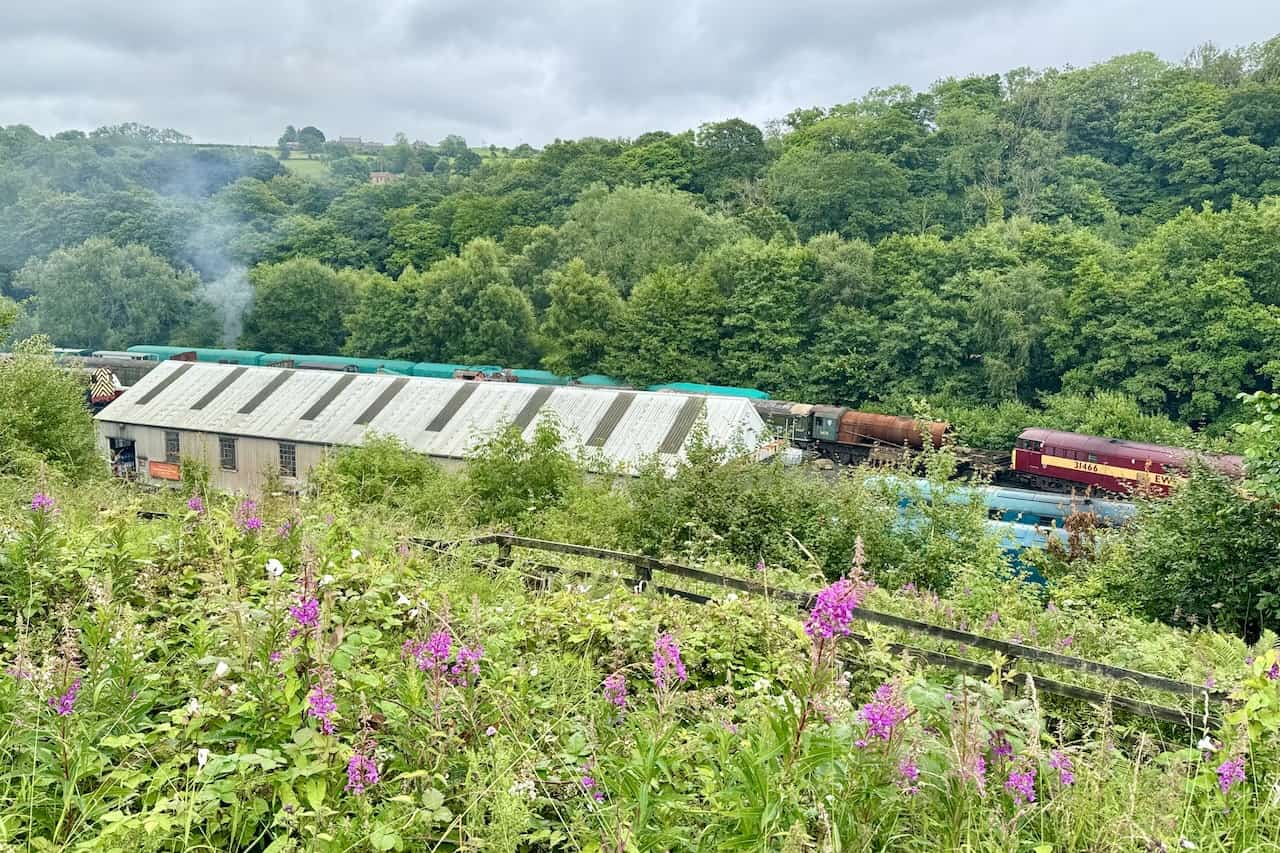 A viewpoint overlooking the North Yorkshire Moors Railway engine sheds and workshops, with a bench for resting.