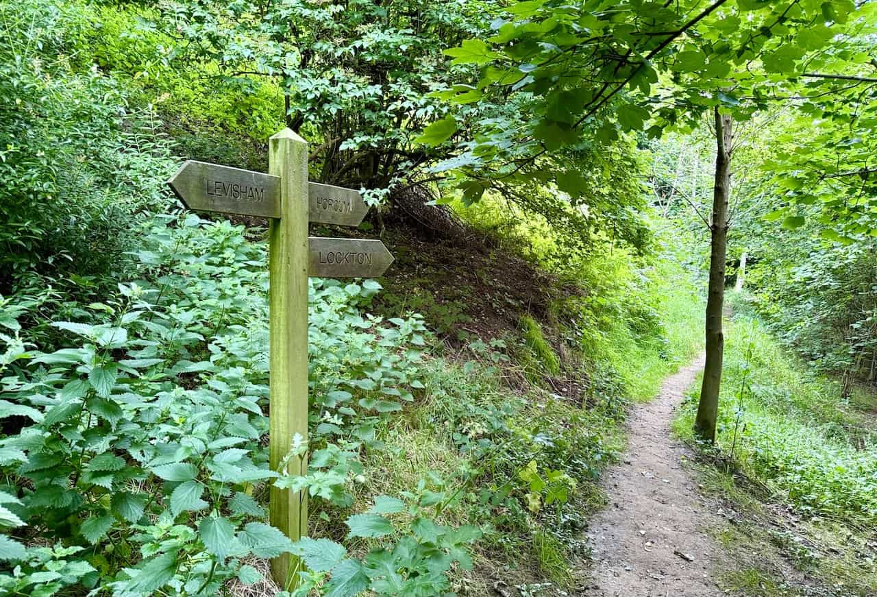 Woodland path with a signpost directing towards Horcum, avoiding the downhill path to Lockton.