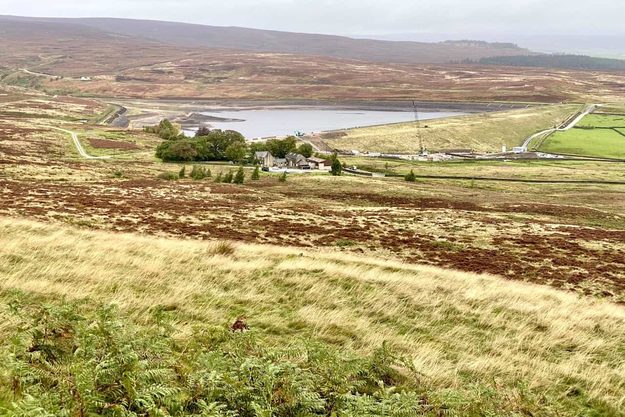 View from the car park at the start of the Barden Moor walk, looking towards Lower Barden Reservoir with the track on the left-hand side of a large clump of trees.