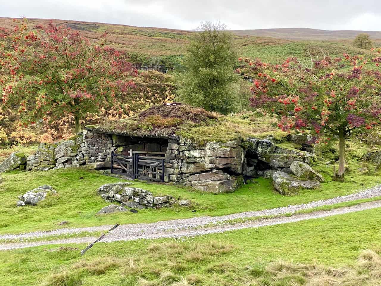 Ornate grouse shooting shelters near Brass Castle, surrounded by vibrant trees and vegetation between Lower and Upper Barden Reservoirs.