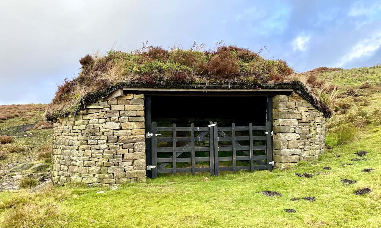 Ornate grouse shooting shelters near Brass Castle, surrounded by vibrant trees and vegetation between Lower and Upper Barden Reservoirs.