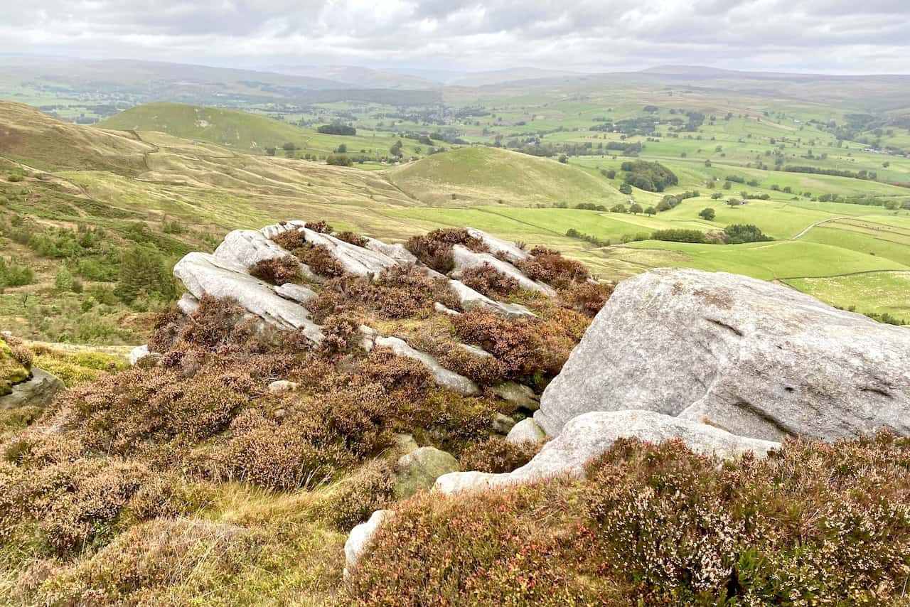 Scenic landscape at Numberstones End with large grey boulders, rocky outcrops, heathland, and rolling hills stretching into the distance.