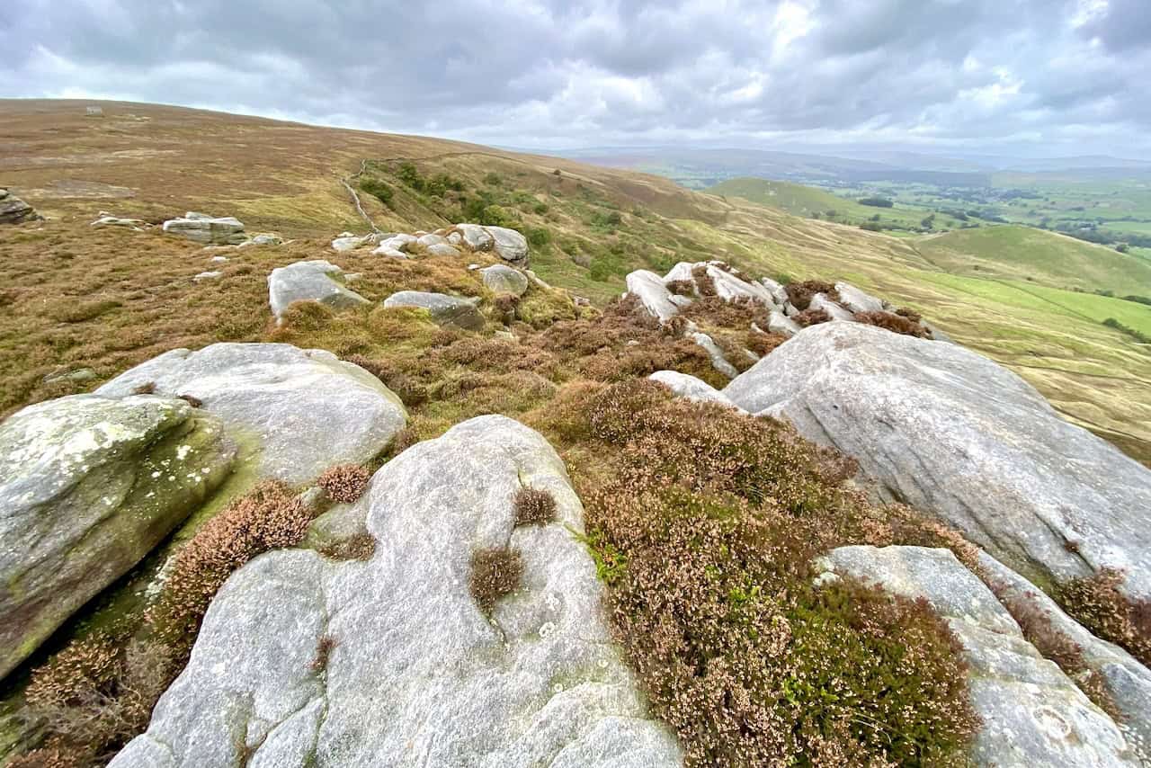 Scenic landscape at Numberstones End with large grey boulders, rocky outcrops, heathland, and rolling hills stretching into the distance.