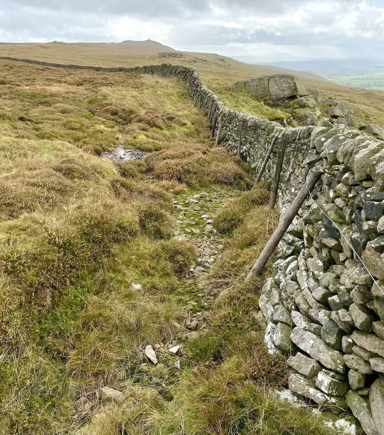 Dry stone wall between Rolling Gate Crags and the Cracoe War Memorial, with a well-used but sometimes boggy route alongside.