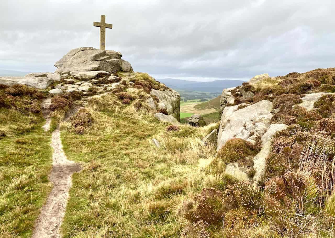 Rylstone Cross at the southern end of the impressive gritstone ridge, with a serene and awe-inspiring landscape view.