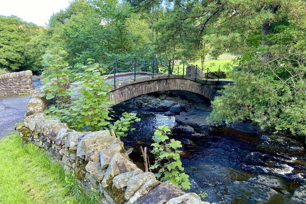 A charming arched bridge over the River Dee at Harbourgill, framed by the tranquil Dentdale valley landscape, enhancing the experience of the Dentdale walk.