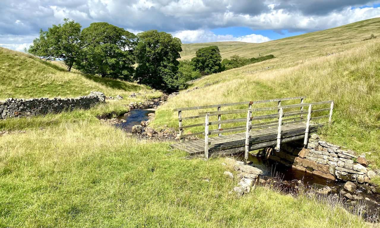 A charming footbridge over a stream near Dent Head Farm, set in the picturesque countryside, concluding the Dentdale walk.