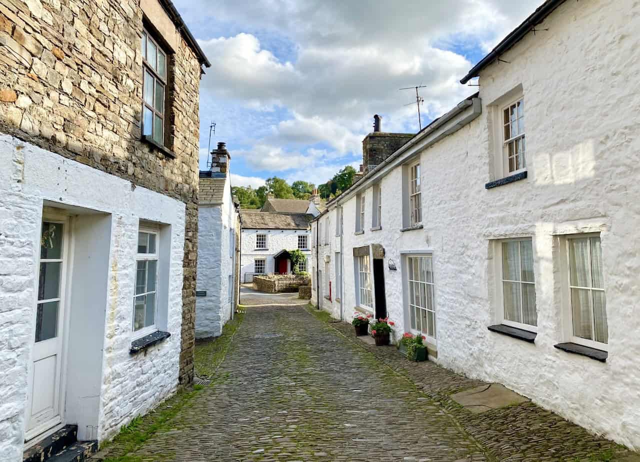 A picturesque scene of Dent village, featuring cobbled streets and charming white-walled cottages, marking the conclusion of the Great Coum walk.