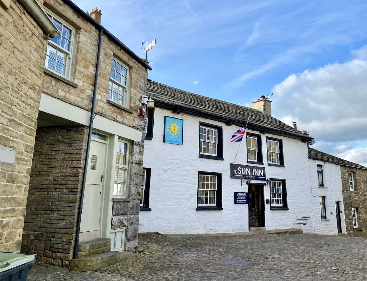 A picturesque scene of Dent village, featuring cobbled streets and charming white-walled cottages, marking the conclusion of the Great Coum walk.