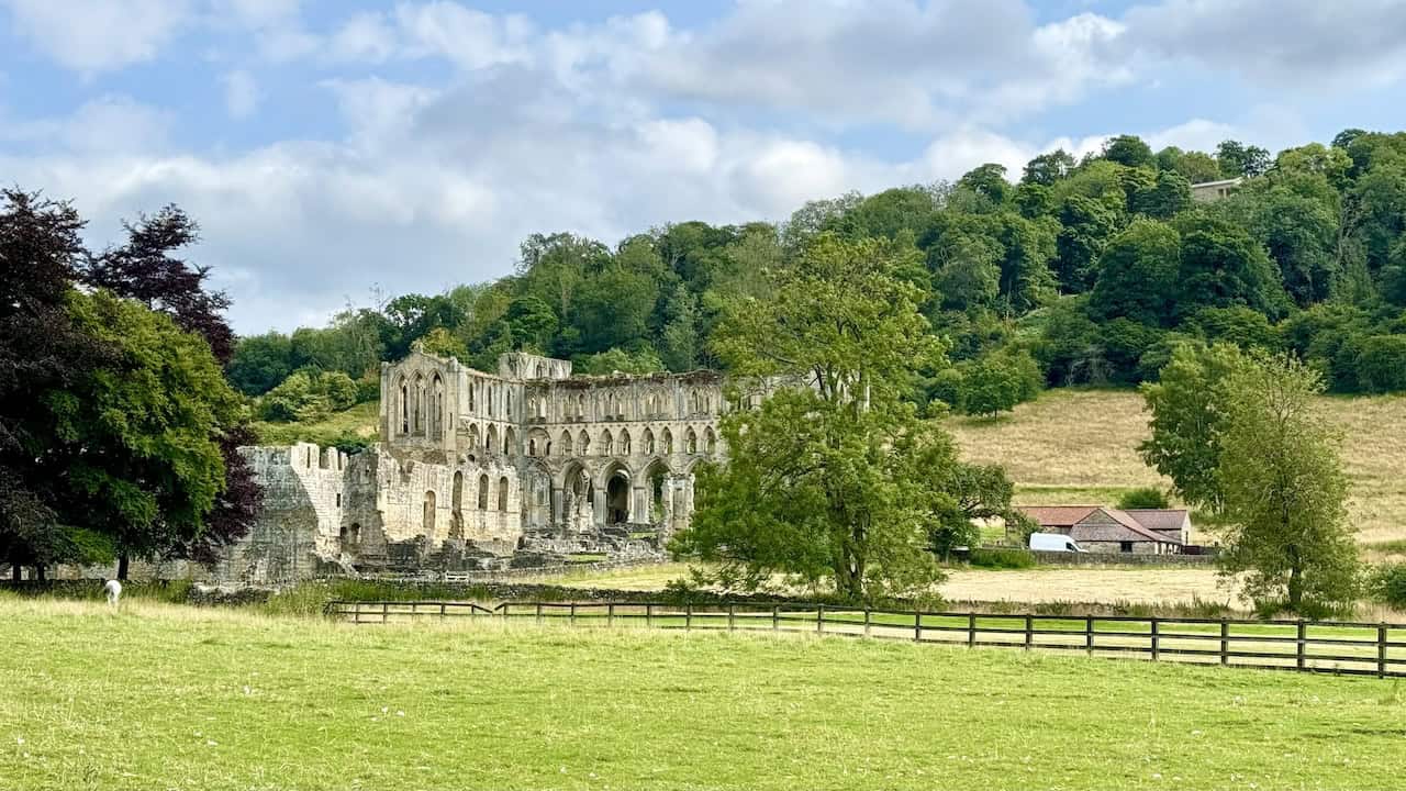 Rievaulx Abbey coming into view on the right-hand side, with a temple from Rievaulx Terrace visible in the trees behind.
