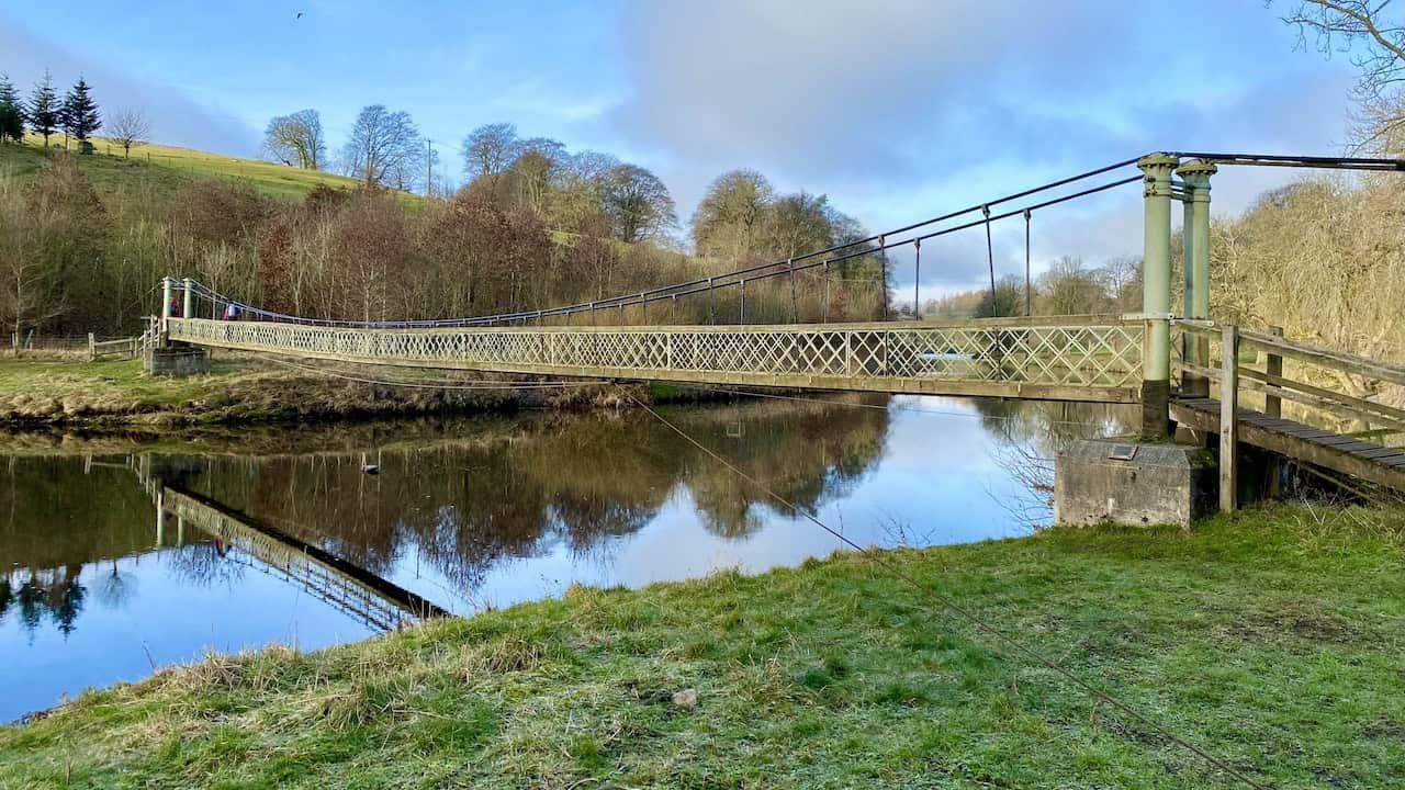 Hebden Suspension Bridge, a historic footbridge built in 1884, providing a scenic crossing over the River Wharfe. 