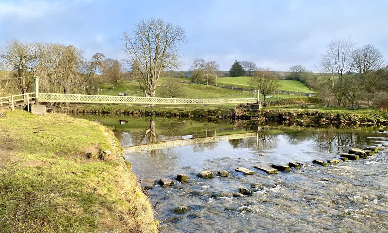 Hebden Suspension Bridge, a historic footbridge built in 1884, providing a scenic crossing over the River Wharfe. 