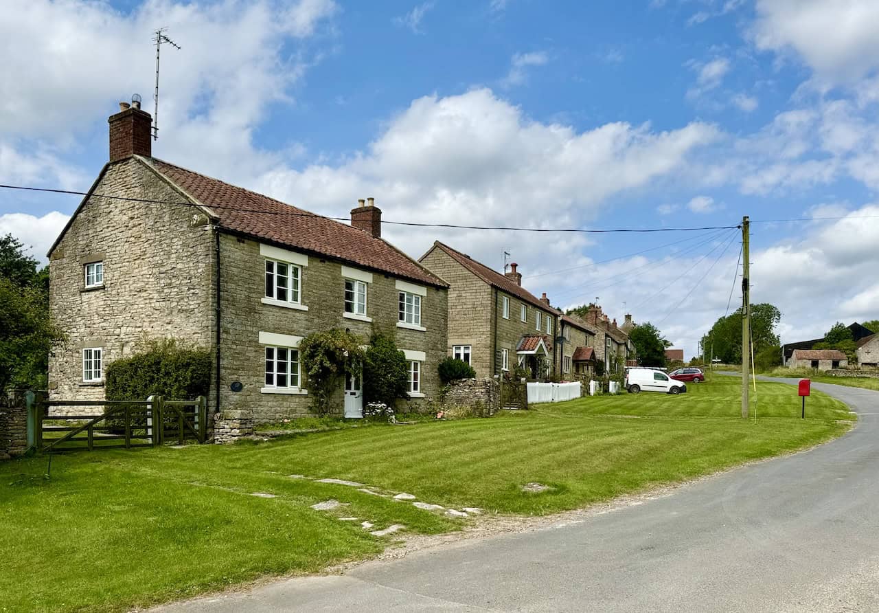 Southern end of Old Byland village, with stone houses and a large village green.
