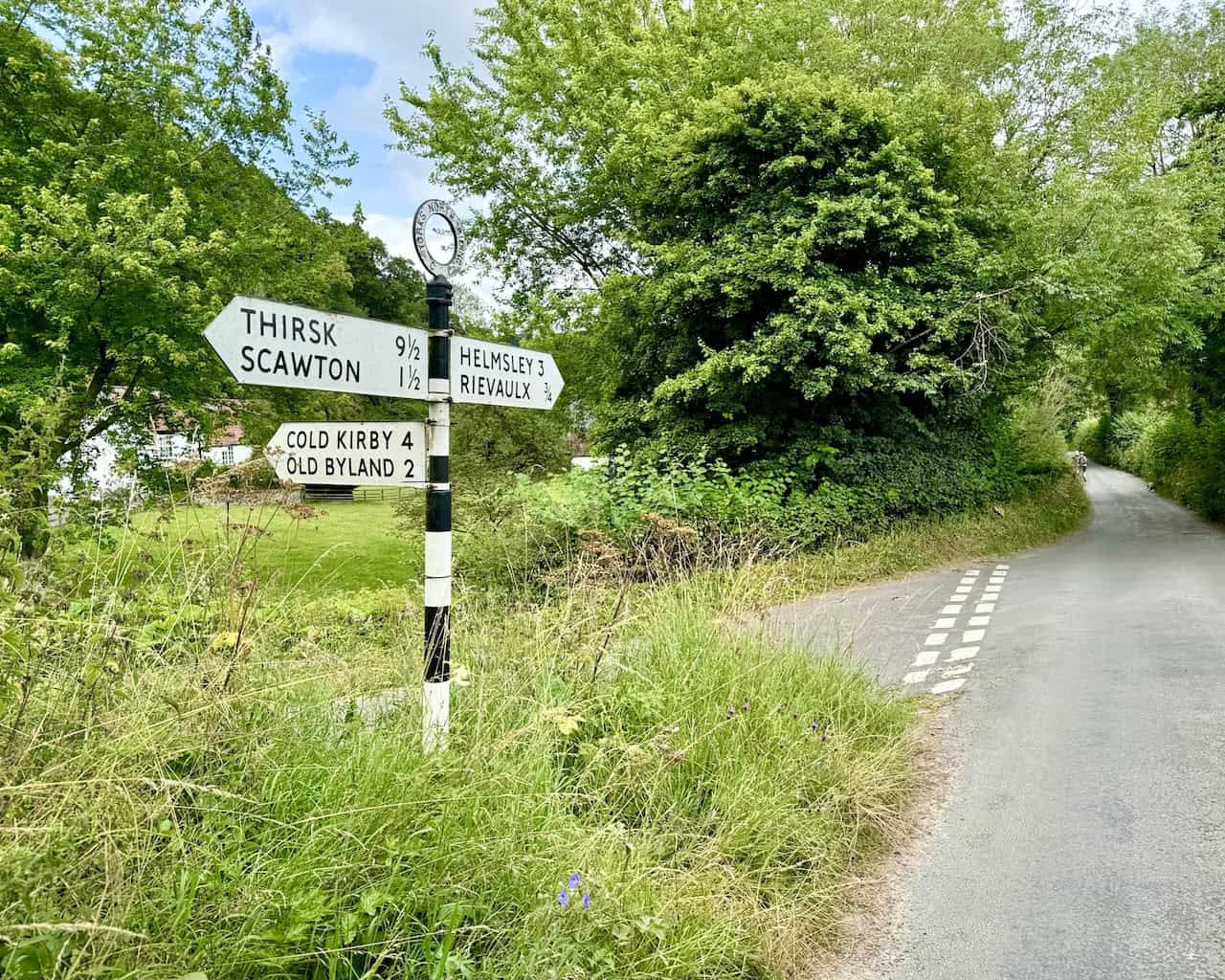 Quiet road crossroads near Hagg Hall, signposted Helmsley and Rievaulx.
