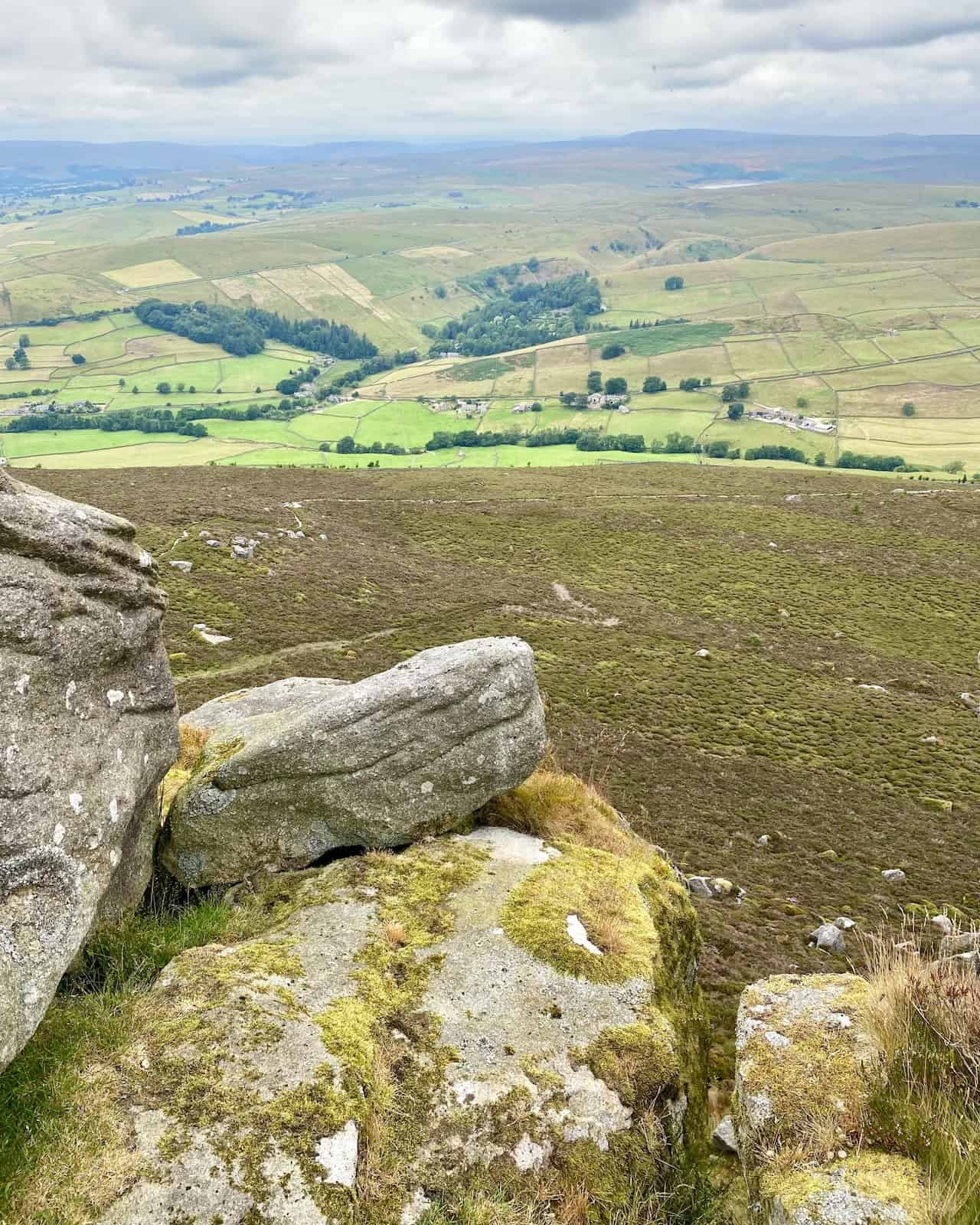 Our trek reaches Simon’s Seat. This striking outcrop of millstone grit rewards us with spectacular views of Wharfedale and beyond, marking the halfway point of our Simon's Seat walk.