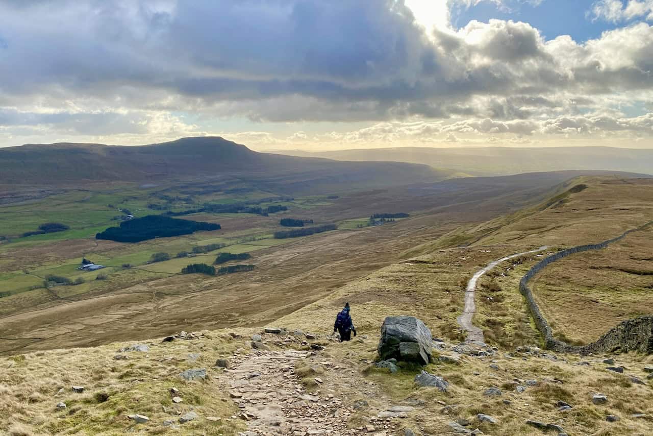 Spectacular view across the valley floor and towards Ingleborough during the descent from Whernside, showcasing its distinctive shape.