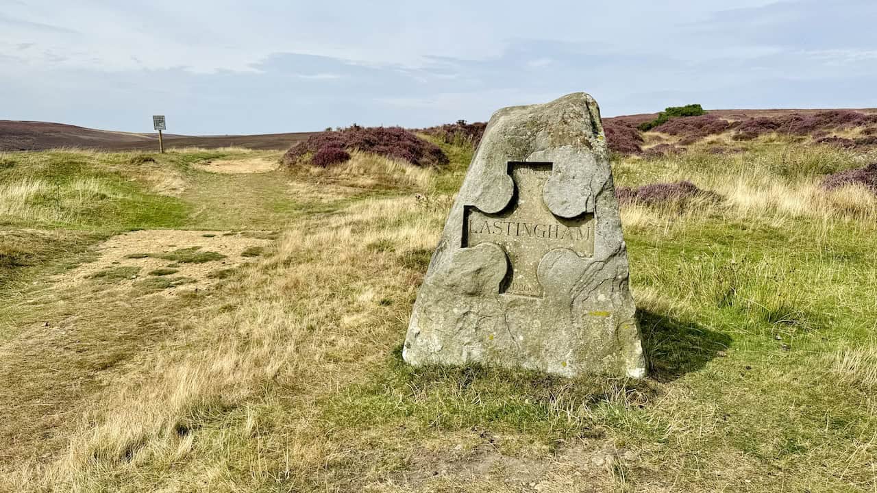 Track leading onto Spaunton Moor, signposted for Rosedale, with a marker stone engraved ‘LASTINGHAM’.
